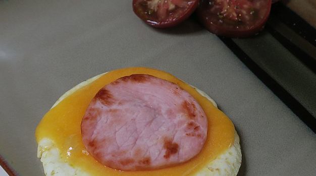 egg stack on a plate with sliced heirloom tomatoes